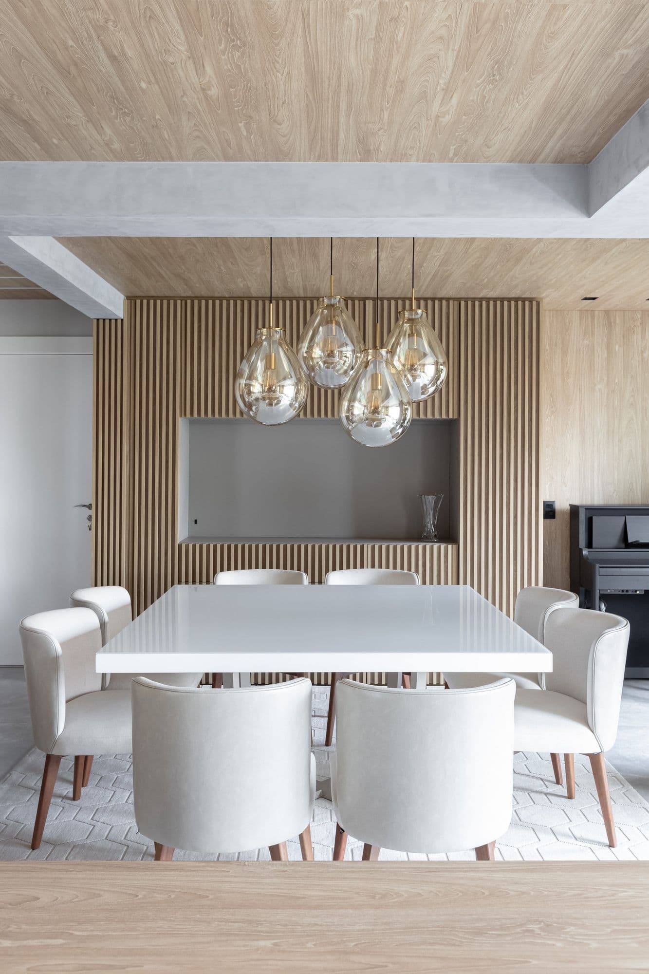 Sala de jantar com painel ripado e pendentes de vidro