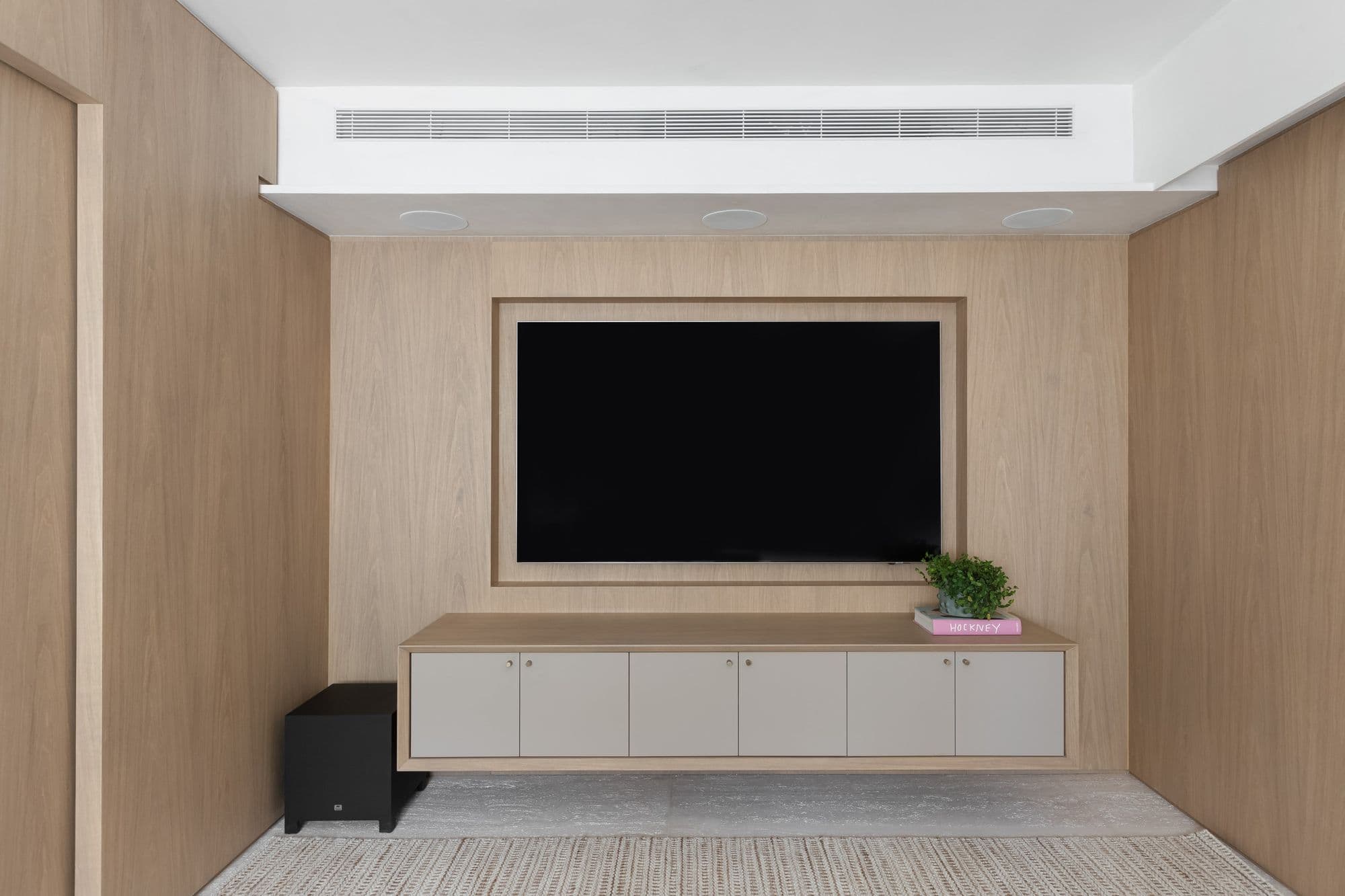 Painel de TV em madeira clara com rack suspenso