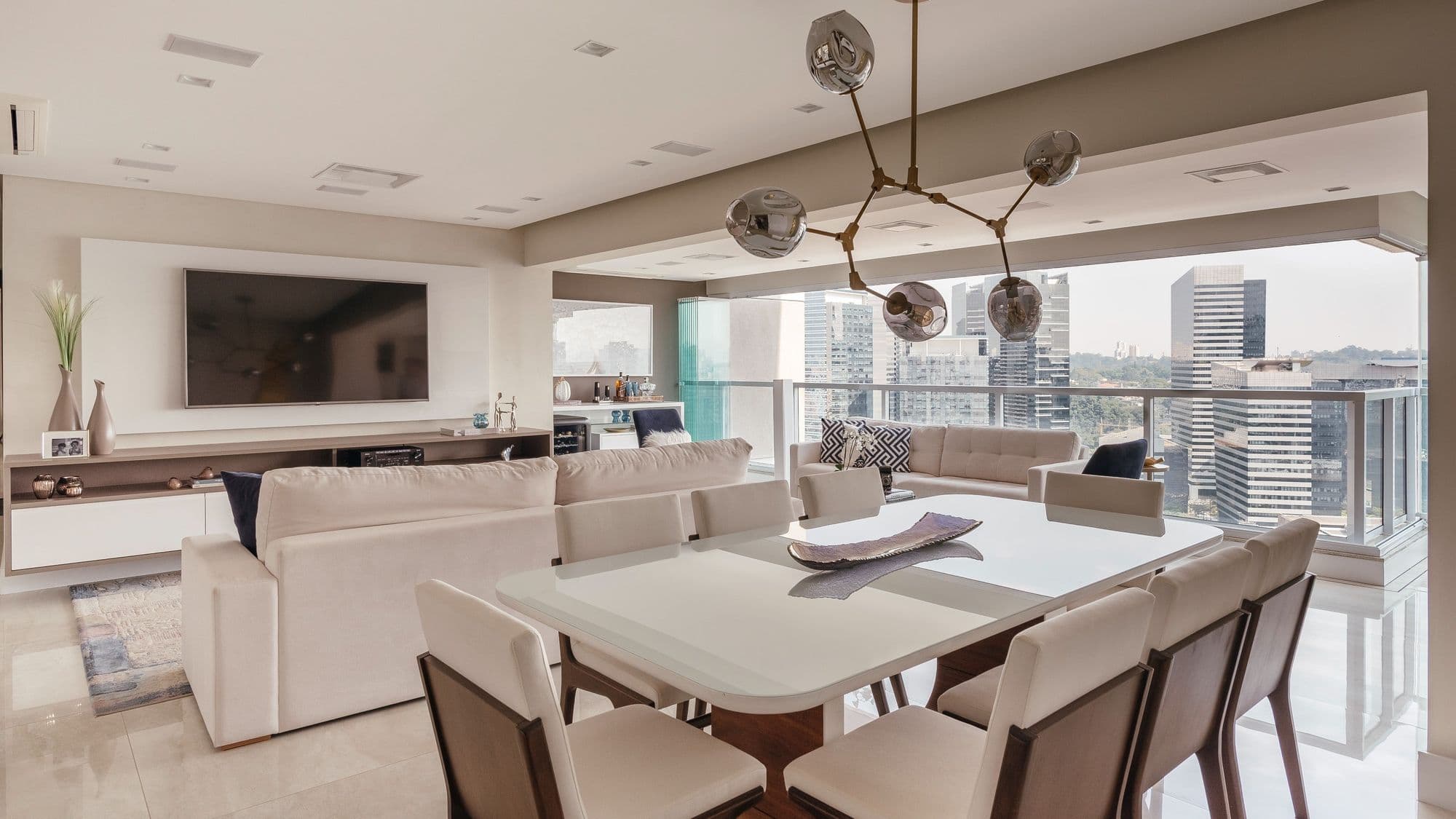 Living com mesa de jantar e vista para os prédios de São Paulo