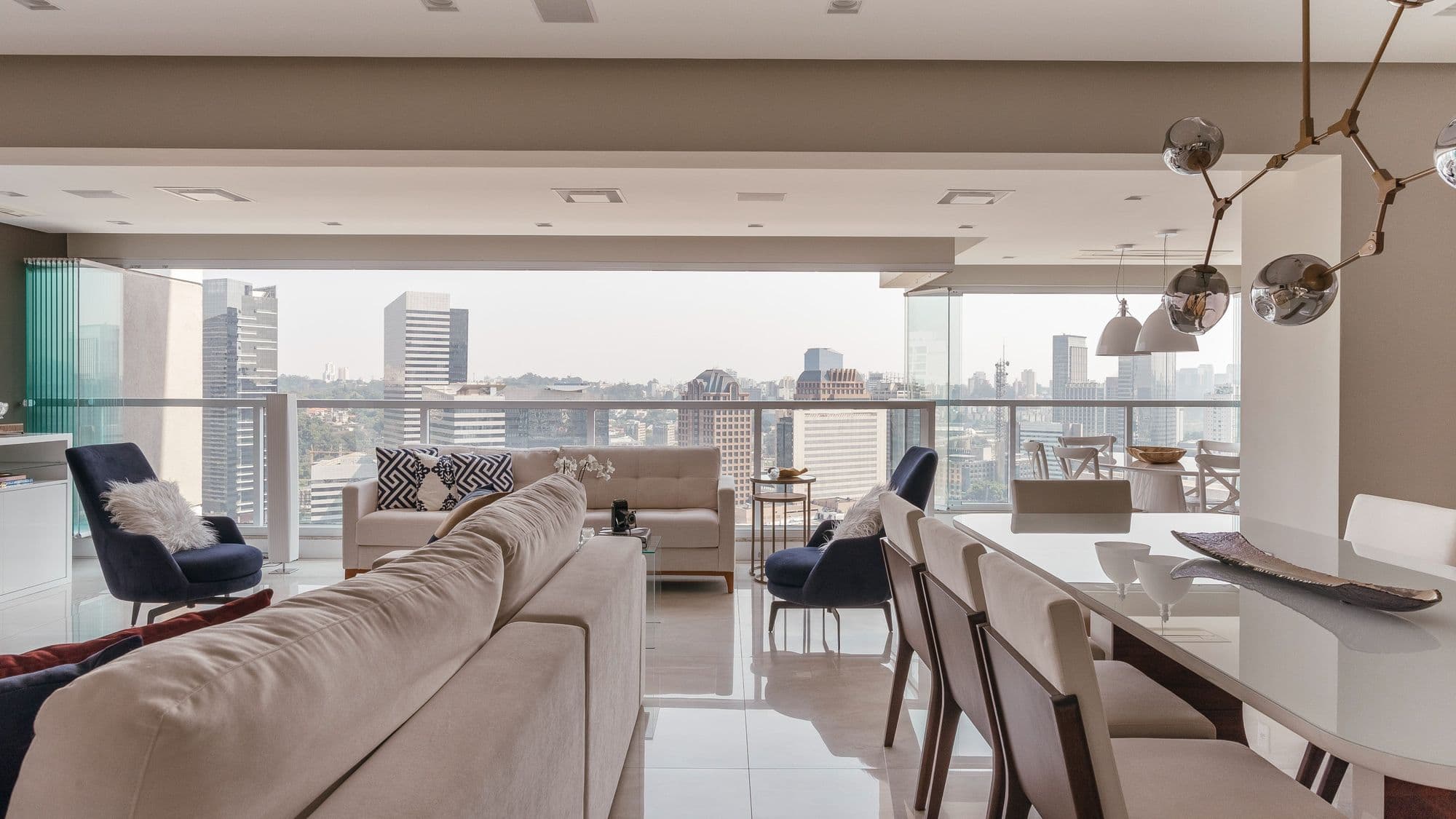 Sala de estar e jantar integradas com varanda envidraçada