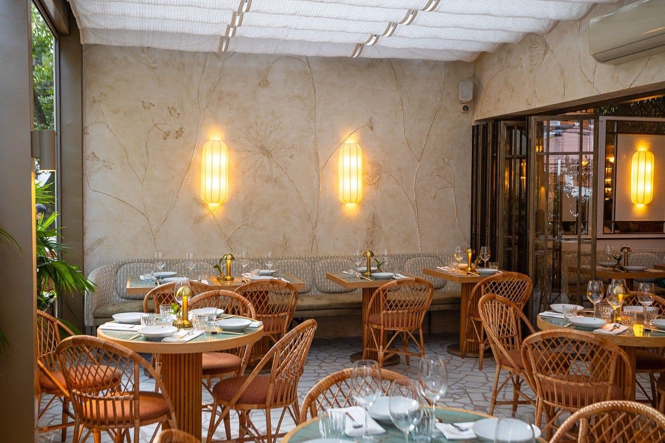 Varanda do restaurante com cadeiras de palhinha e arandelas