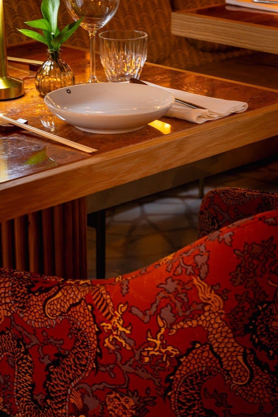 Detalhe da mesa de madeira e da poltrona estampada