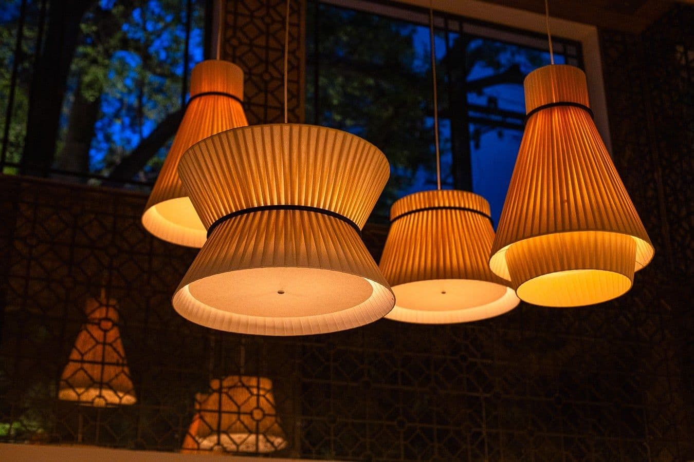 Conjunto de luminárias plissadas acesas à noite