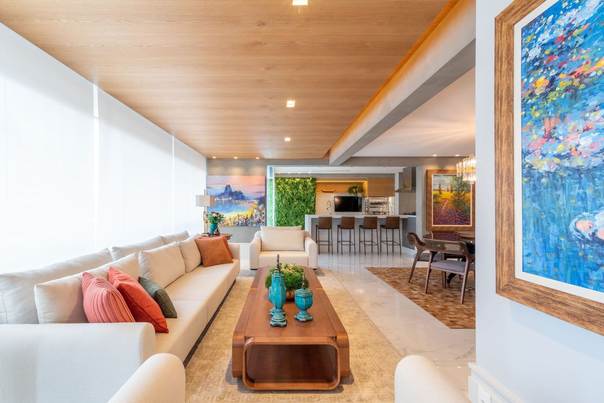 Sala com forro de madeira, quadro colorido e sofá branco