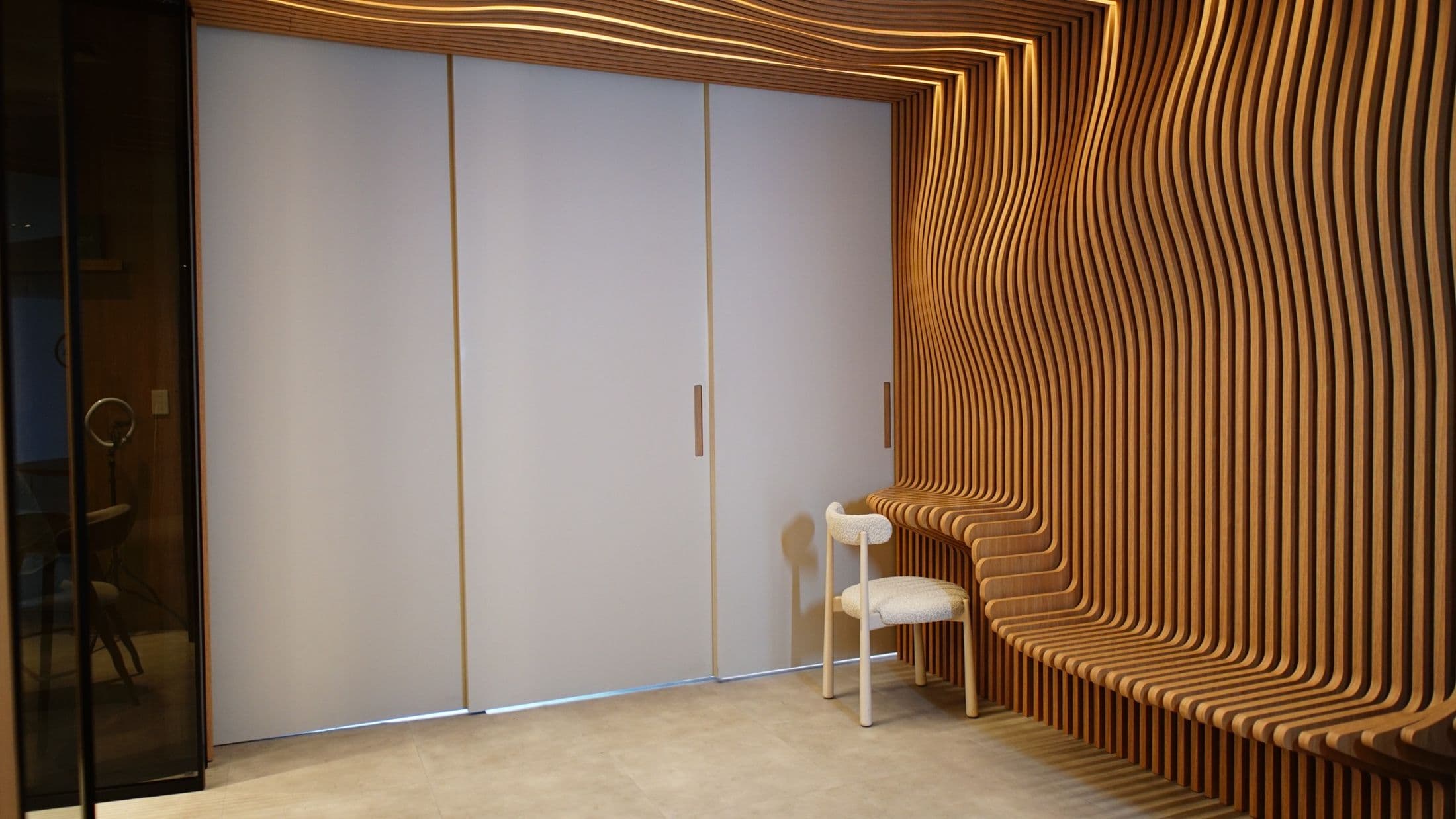 Banco escultural de ripas curvas em madeira no showroom da Casa 46